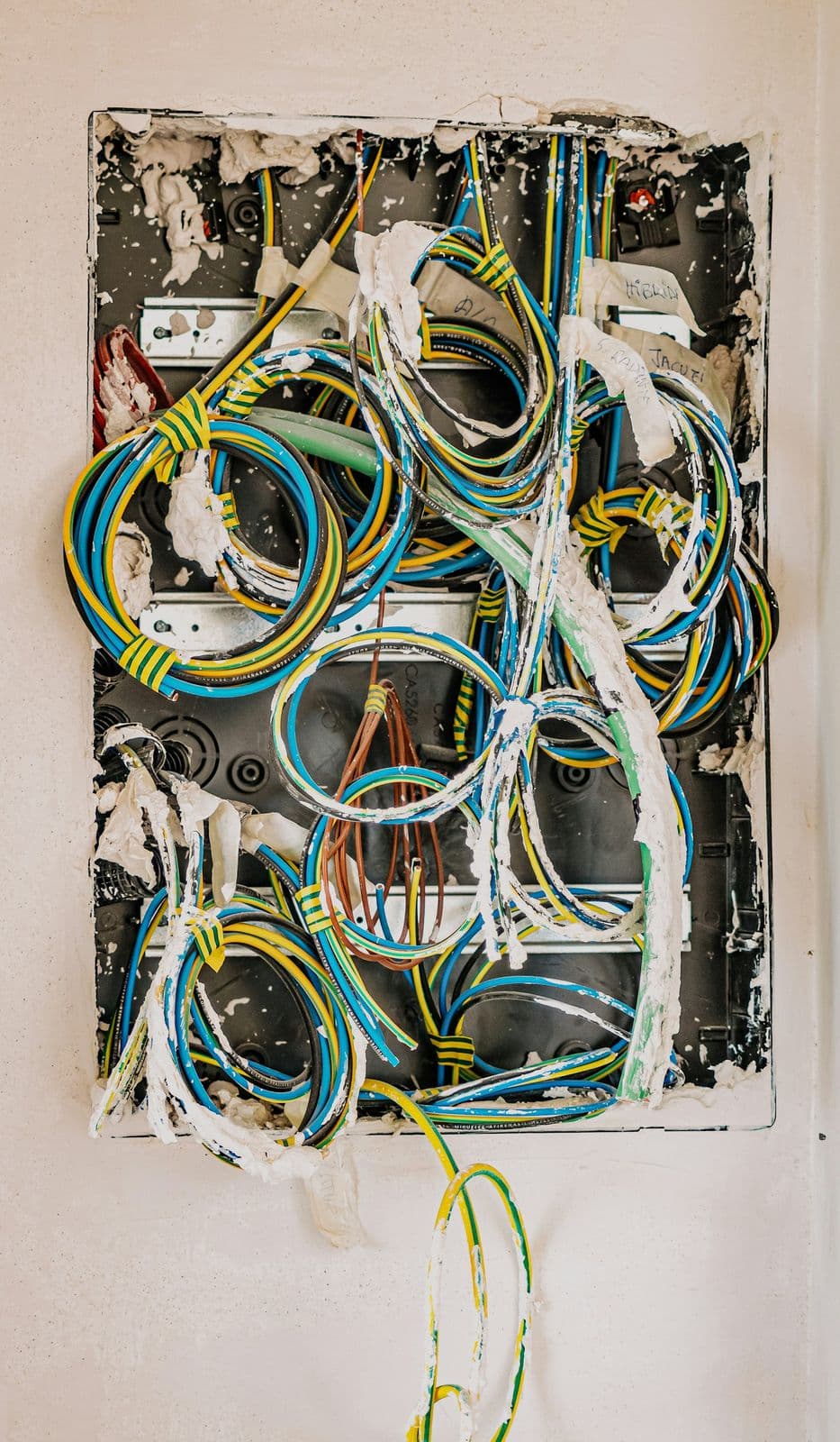 Elektrikár drží trojžilový kábel pri stene